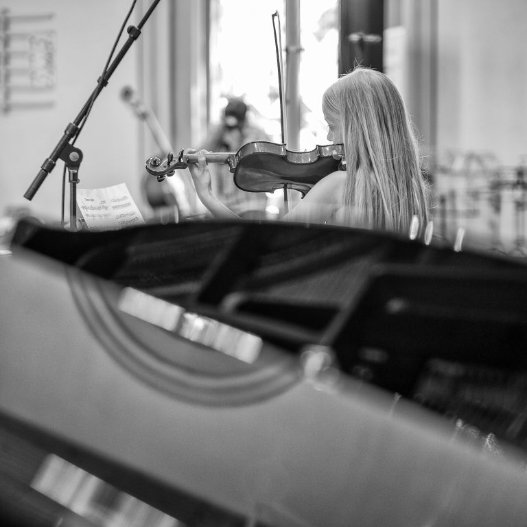 Violinenunterricht Mädchen vor dem Flügel mit Violine